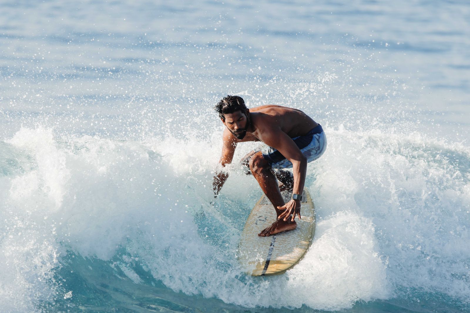 Surfer riding a breaking wave in tropical waters